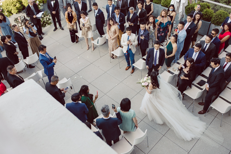 Public Hotel NYC spring rooftop wedding with Stella and Peter. NYC began to loosen COVID restrictions so events and weddings were finally allowed. Stella and Peter were able to keep their original wedding date, but unfortunately Stella's parents couldn't make it to the wedding due to COVID travel restrictions. Stella and Peter's wedding took place on 17th floor with rooftop access at the Public Hotel. Their wedding ceremony was on the rooftop, as well as their first look and some photos then we wandered around the hotel and took some epic photos at the pent house and escalator. Public Hotel NYC was so fun to photograph and I had the coolest, the most chill couple to work with. Stella and Peter's epic wedding at Public Hotel NYC photographed by Karis | Hey Karis.